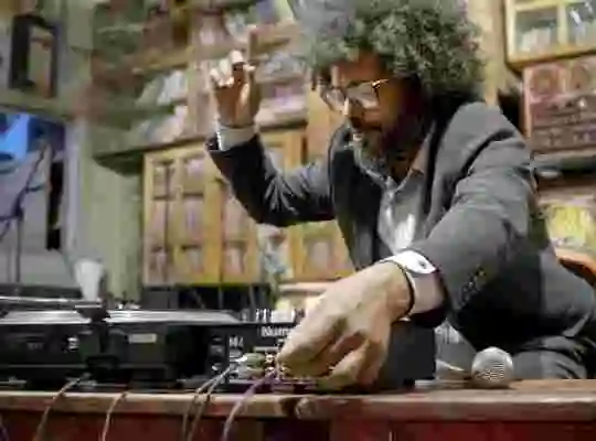 En person justerar sladdar på en DJ Mixer på ett musikställe.