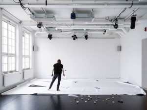 Dansare i installation av papper och objekt i dansstudio