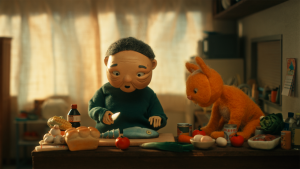 Stillbild från den animerade stop-motionfilmen Budo. På bilden syns två dockor som lagar mat i ett kök.