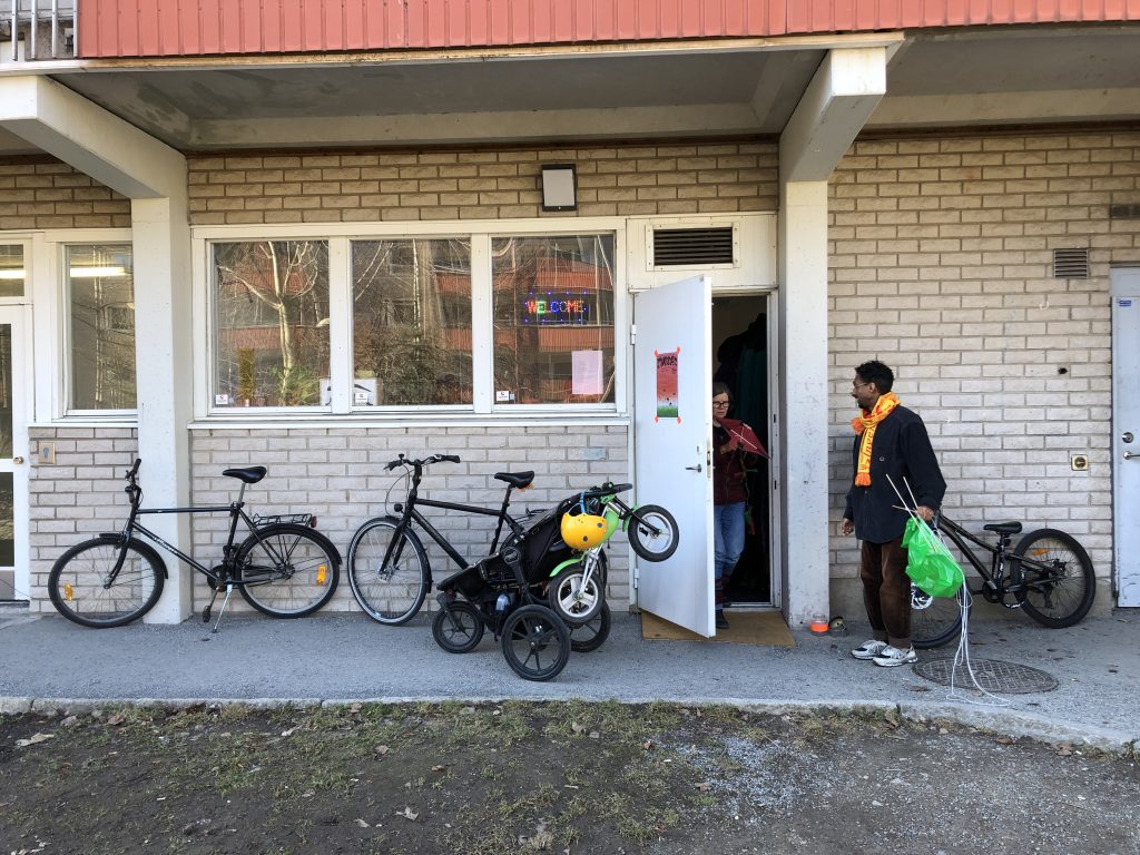 Entrance in apartment building with man being greated by woman